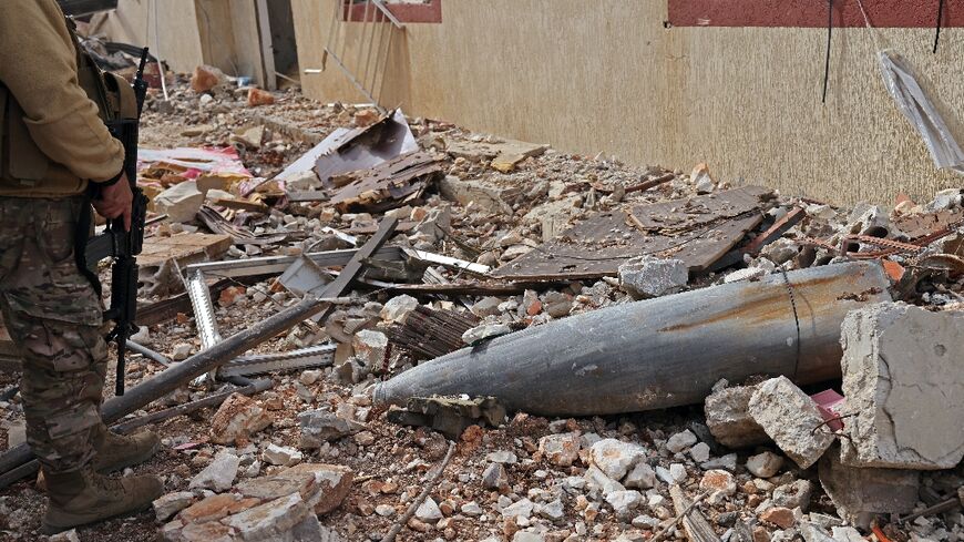 A Lebanese soldier in Naqura, south Lebanon, checks the remains of a rocket in a residential area devastated by the war between Israel and Hezbollah