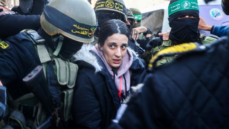 Masked fighters of Hamas and its ally Islamic Jihad struggle to clear a path through crowds of Palestinian spectators for Israeli civilian Arbel Yehud ahead of her release with other hostages