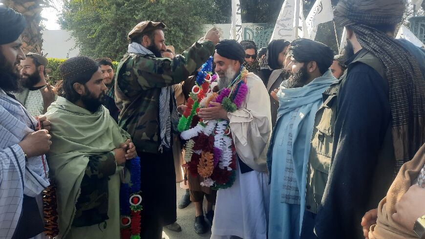 Taliban authorities welcomed Afghan fighter Khan Mohammed (C) who was imprisoned in the United States, as he arrived in Jalalabad in eastern Nangarhar province