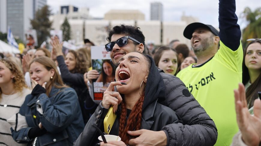 Members of a crowd gathered in Tel Aviv react during the livestreamed release of four women soldiers held hostage in Gaza 