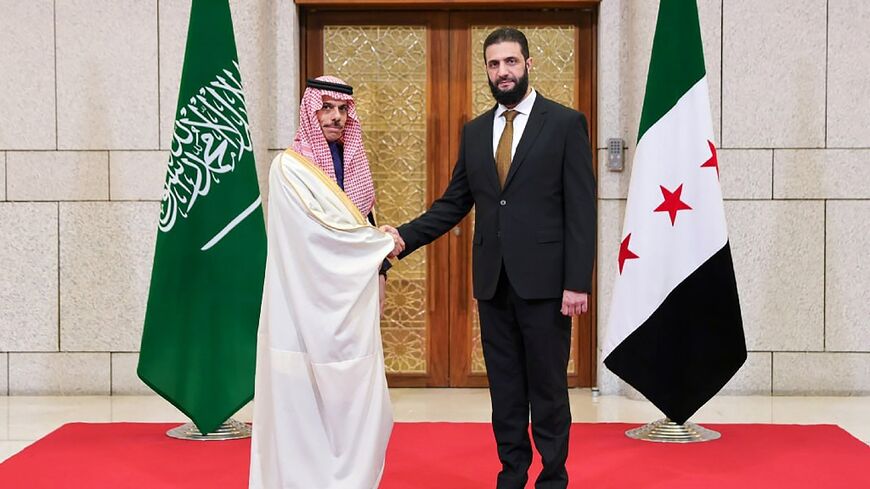 This handout picture released by the Syrian Arab News Agency SANA shows Syria's new leader Ahmed al-Sharaa welcoming Saudi Arabia's Foreign Minister Faisal bin Farhan in Damascus