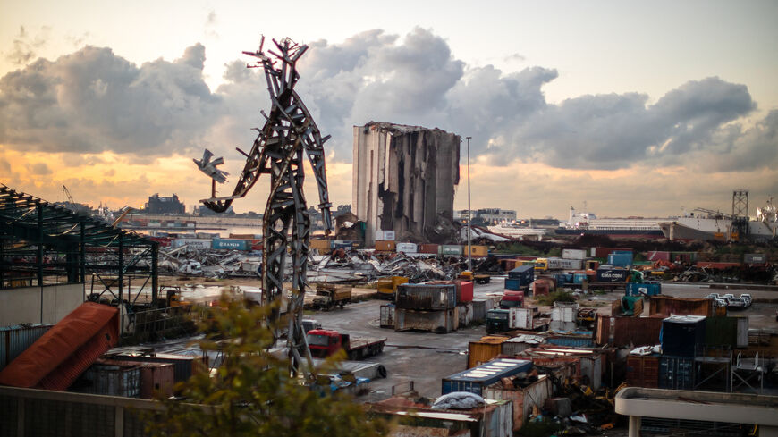 The destroyed grain silos and a sculpture made from salvaged steel following the explosion stand in the port of Beirut as the sun sets on Lebanon, Jan. 11, 2024.