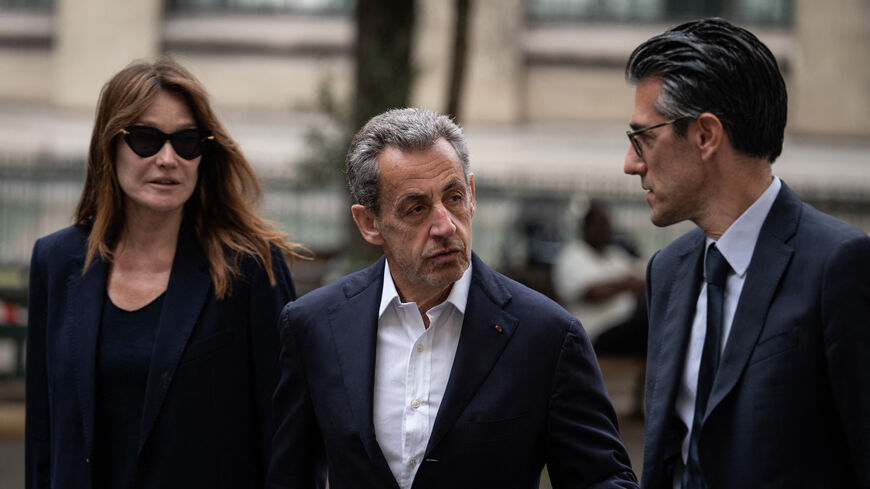 French former president Nicolas Sarkozy (C) and his wife Carla Bruni-Sarkozy arrive to vote for the first round of parliamentary elections in Paris, on June 30, 2024. A divided France is voting in high-stakes parliamentary elections that could see the anti-immigrant and eurosceptic party of Marine Le Pen sweep to power in a historic first. The candidates formally ended their frantic campaigns at midnight June 28, with political activity banned until the first round of voting. (Photo by ARNAUD FINISTRE / AFP