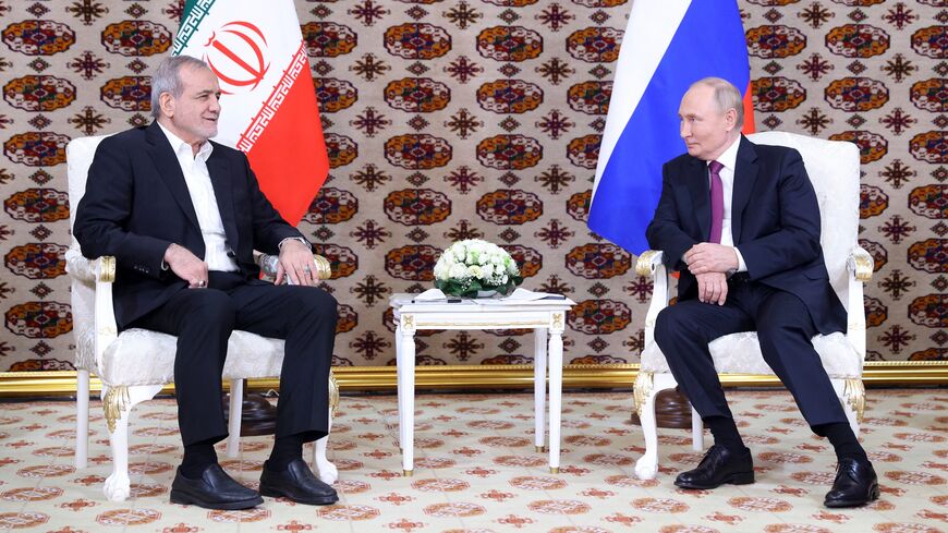 In this pool photograph distributed by the Russian state agency Sputnik, Russia's President Vladimir Putin meets with Iran's President Masoud Pezeshkian on the sidelines of an international forum "Interrelation of times and civilizations - basis of peace and development" in Ashgabat on Oct. 11, 2024. 