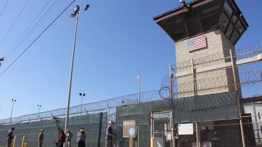 People walk past a guard tower outside the fencing of Camp 5 at the US Military's Prison in Guantanamo Bay, Cuba, on Jan, 26, 2017. 