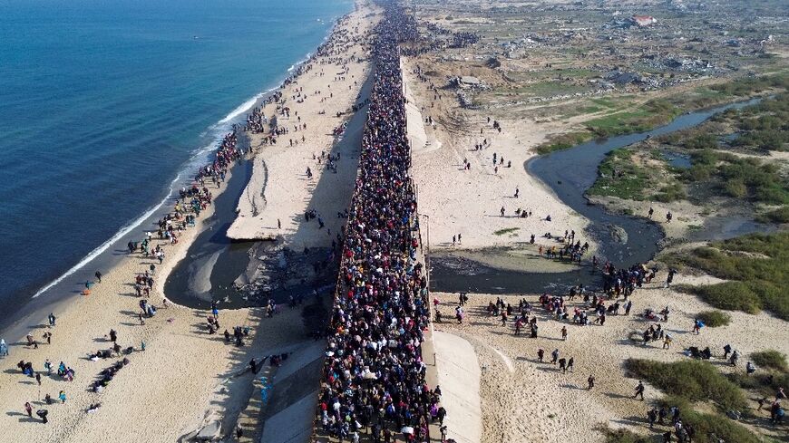 Displaced Gazans walk north along the coast after Israel reopened access to the territory's north on Monday