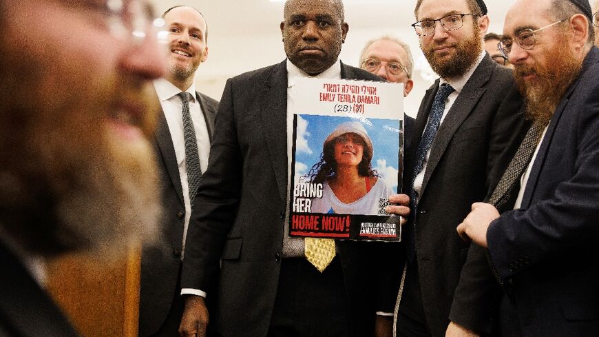 Britain's Foreign Secretary David Lammy holding a poster showing hostage Emily Damari 