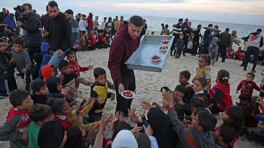 Hamada Shaqura, a former food blogger, distributes food after cooking a meal for displaced Palestinians in Khan Yunis, southern Gaza