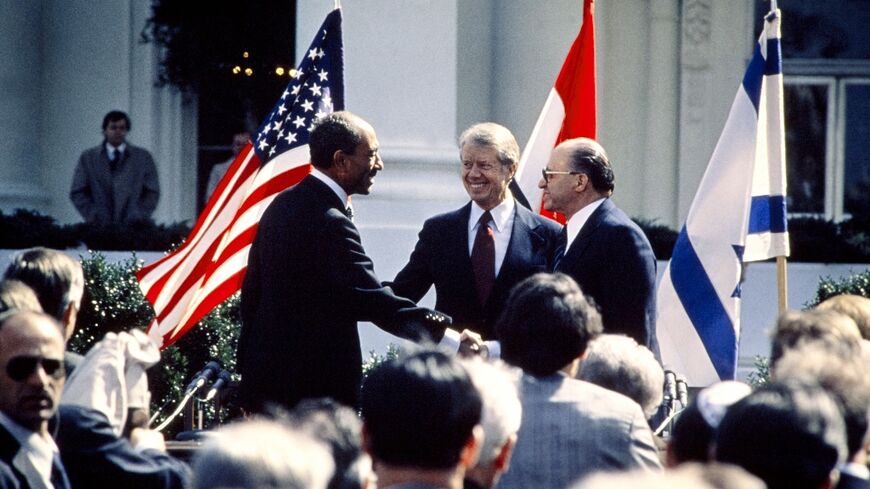 US President Jimmy Carter (C) congratulates Egyptian President Anwar al-Sadat (L) and Israeli Prime Minister Menachem Begin (R) on March 26, 1979 on the north lawn of the White House after the signing of a historic peace treaty