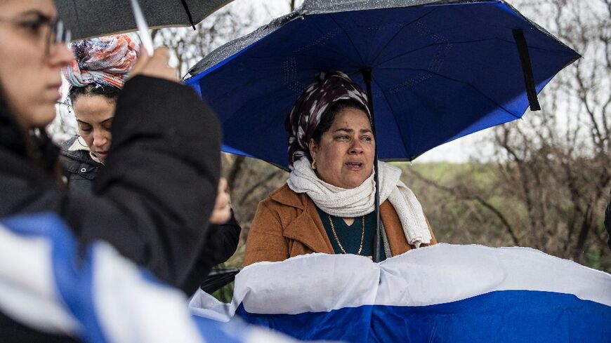 Flag-waving Israelis line the route of the convoy carrying the bodies of four hostages handed over by Hamas in Gaza.