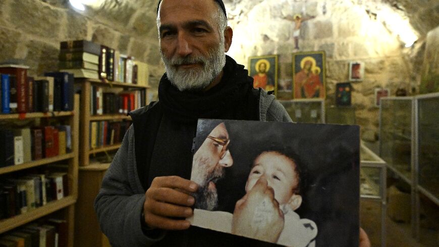 Father Jihad Youssef, carrying a picture of Italian Jesuit priest Paolo Dall'Ogli