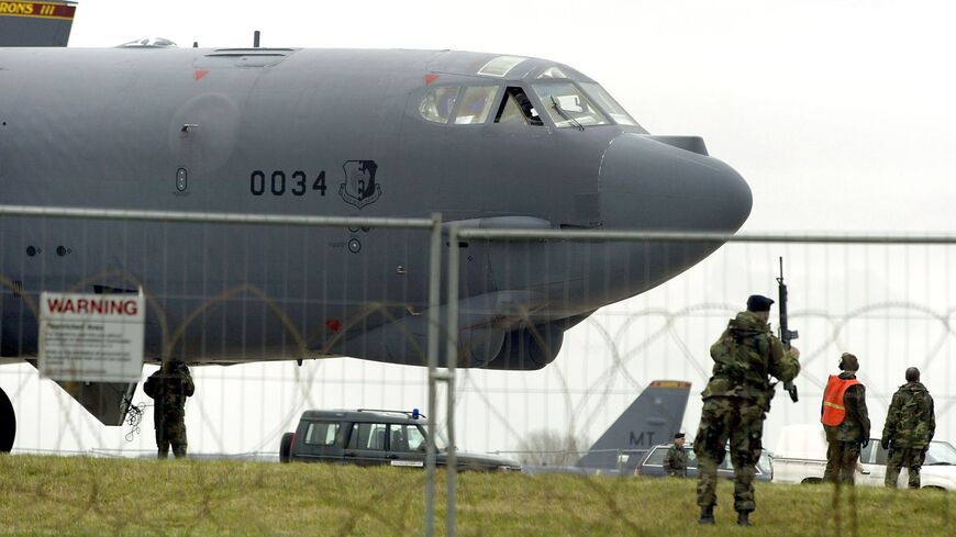 A US serviceman patrols the runway after an American B-52 bomber lands at Fairford Royal Air Force base March 4, 2003.