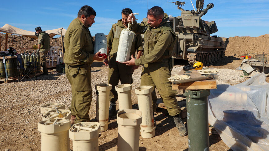 Israeli soldiers prepare munitions near a self-propelled artillery howitzer in southern Israel near the border with the Gaza Strip on December 16, 2023, amid ongoing battles between Israel and the Palestinian militant group Hamas. (Photo by GIL COHEN-MAGEN / AFP) (Photo by GIL COHEN-MAGEN/AFP via Getty Images)