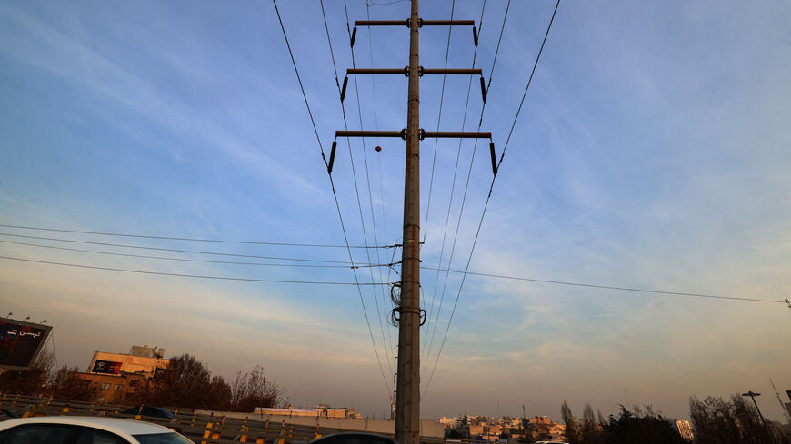 Traffic flows on a main road past electricity transmission towers in Tehran on December 16, 2024. Iran has suspended operations at several power plants over fuel shortages that have been intensified by rising demand during a spell of freezing weather. (Photo by ATTA KENARE / AFP) (Photo by ATTA KENARE/AFP via Getty Images)