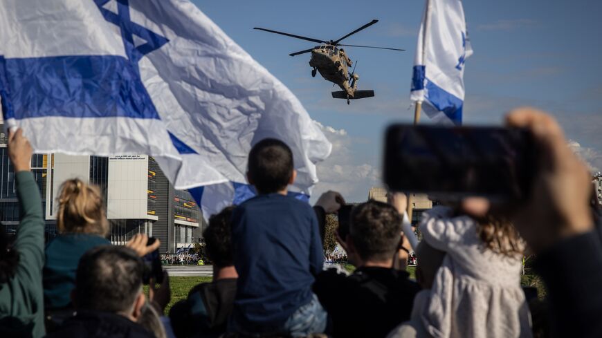 People watch and wave as a helicopter, part of the hostage-release convoy, lands at Belinson-Schneider Hospital on Jan. 25, 2025, in Tel Aviv, Israel.