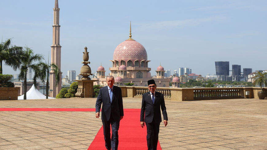 Turkey's President Recep Tayyip Erdogan (L) and Malaysia's Prime Minister Anwar Ibrahim (R) walk after a welcome ceremony in Putrajaya on February 11, 2025. (Photo by FAZRY ISMAIL / POOL / AFP) (Photo by FAZRY ISMAIL/POOL/AFP via Getty Images)