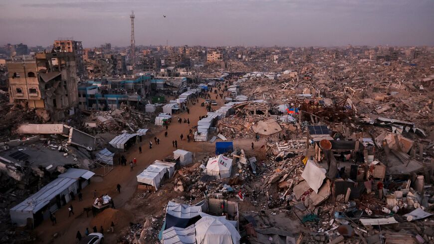 Palestinians walk past tents lining the streets amid the rubble of destroyed buildings in Jabalia, in the northern Gaza Strip on Feb. 18, 2025. 