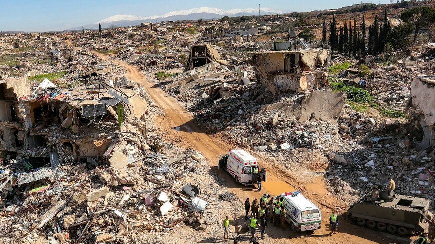 Ambulances and Lebanese army vehicles amid the rubble of destroyed buildings in Kfar Kila