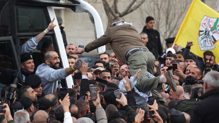 A man launches himself from the crowd to greet a returning Palestinian prisoner