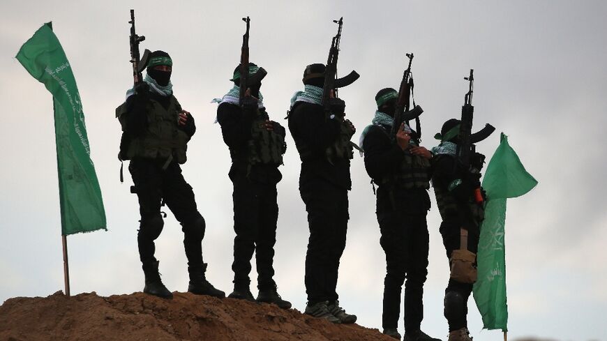 Palestinian Hamas militants gather at the site of the handover of four Israeli hostages' bodies