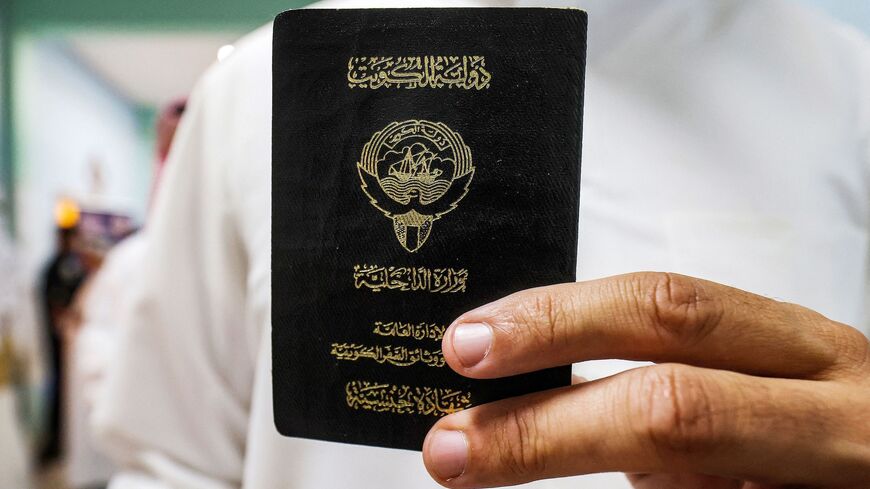 A voter holds his proof of Kuwaiti citizenship upon arriving at a polling station during parliamentary elections in Kuwait City on June 6, 2023. 