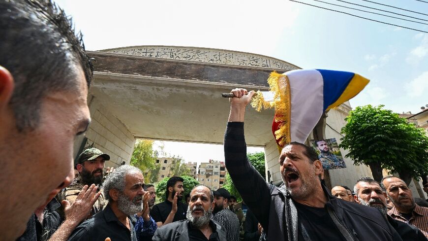 Members of Syria's Druze community wave flags and chant slogans during the funeral of people killed during clashes with Syrian security forces on April 30, 2025