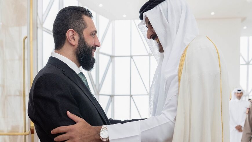 This handout picture released by Qatar's Royal Palace shows the Gulf state's Emir Sheikh Tamim bin Hamad al-Thani welcoming Syria's interim President Ahmad al-Sharaa in Doha