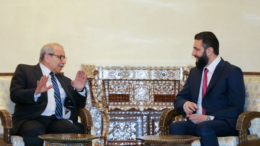 A handout picture released by the Lebanese government shows Prime Minister Nawaf Salam (L) meeting Syrian leader Ahmed al-Sharaa in Damascus on Monday