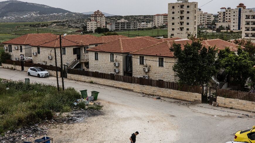 A man walks between empty student residences used by displaced families as shelters at the Arab American University outside Jenin, in the occupied West Bank