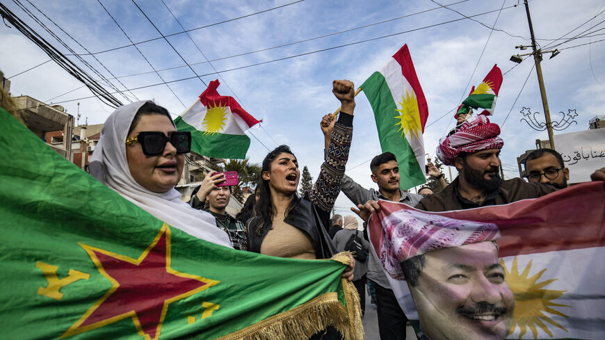Syrian Kurds chant slogans and wave flags as they demonstrate in the northeastern city of Qamishli on March 14, 2025, against the new constitutional declaration announced by the interim government in Damascus the previous day.