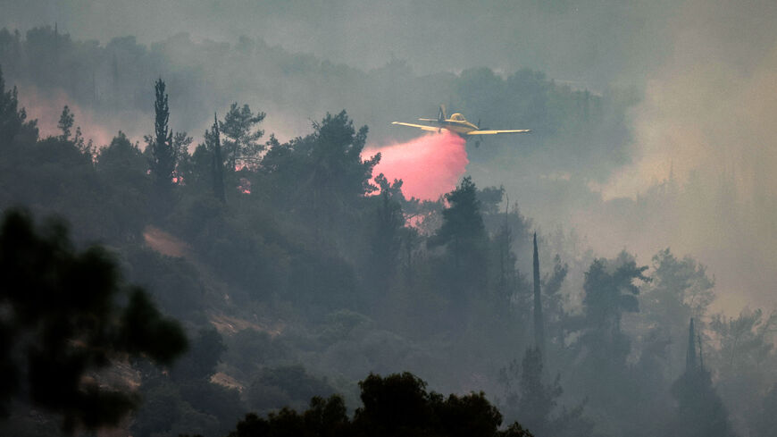 An Air Tractor AT-802AF firefighting aircraft drops flame retardant while trying to extinguish a forest fire near the central Israeli town of Bet Shemesh, near Jerusalem on April 23, 2025. (Photo by Ahmad GHARABLI / AFP) (Photo by AHMAD GHARABLI/AFP via Getty Images)
