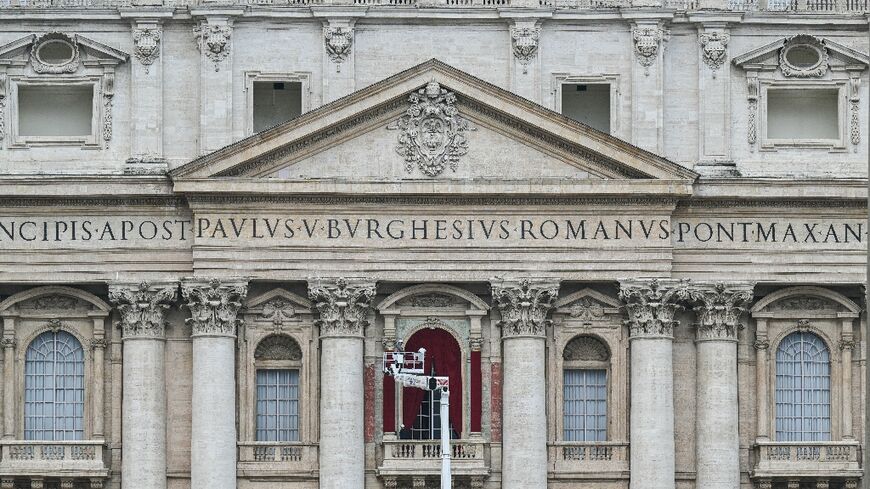 A worker prepares the main central balcony of St Peter's basilica