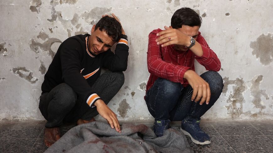 Palestinian men mourn at Gaza City's Al-Ahli Hospital after an Israeli strike on a school-turned-shelter killed 15 people in the Tuffah neighbourhood, the civil defence agency said.