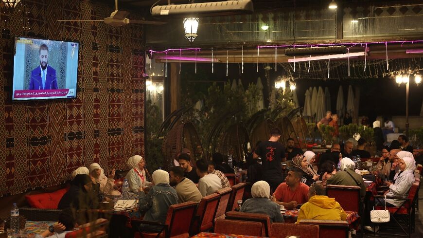 Syrians watch a televised speech by Syria's leader Ahmed al-Sharaa -- who until recently was on a US wanted list over jihadist connections -- at a cafe in Aleppo on May 14, 2025