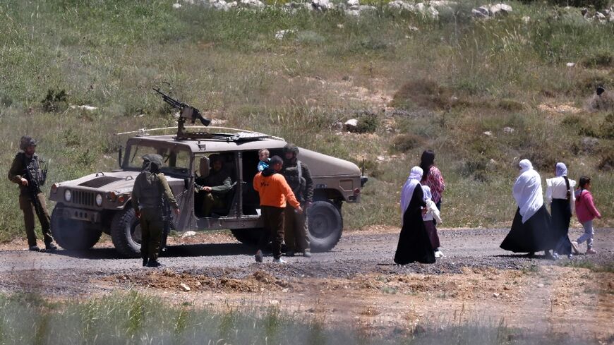 Israeli soldiers stop a Syrian Druze family, who fled sectarian violence outside Damascus, from crossing the buffer zone that used to separate Israeli and Syrian forces on Golan Heights.
