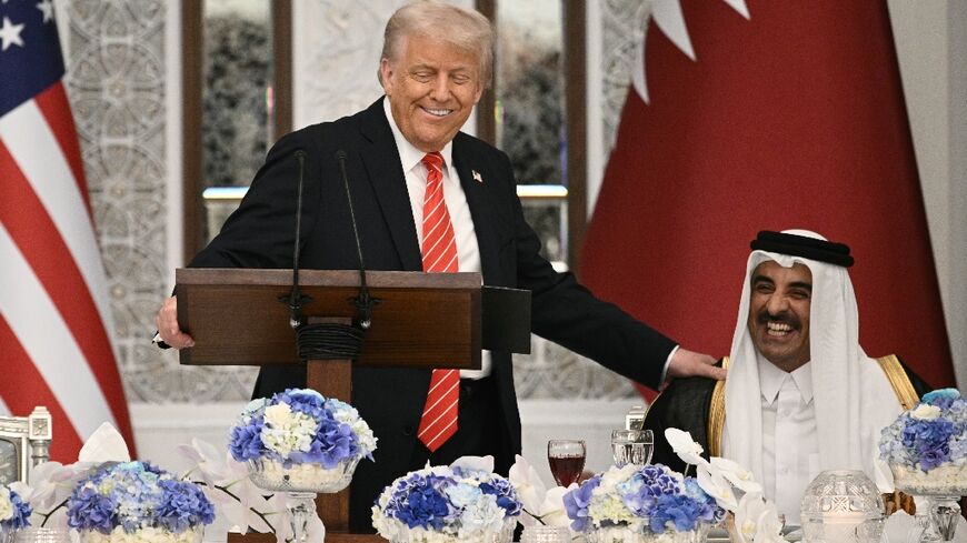 US President Donald Trump speaks with Qatar's Emir Sheikh Tamim bin Hamad al-Thani at the start of a state dinner at the Lusail Palace in Doha