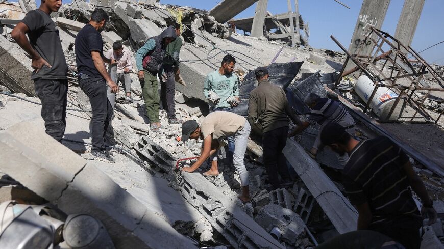 Palestinians sift through the rubble after a strike on northern Gaza's Jabalia