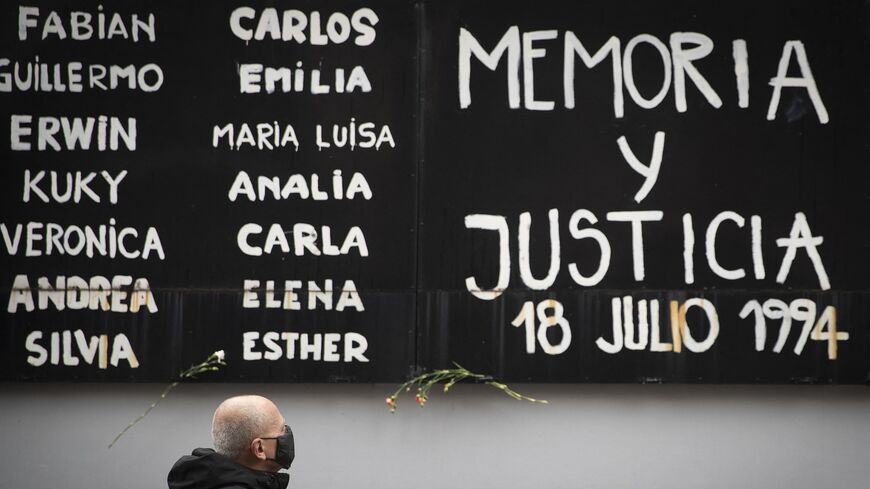 A man pays tribute during the commemoration of the 26th anniversary of a bomb attack