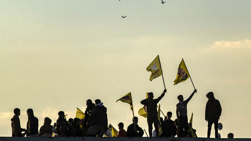 Syrian Kurds wave flags bearing pictures of the founder of the Kurdistan Workers' Party (PKK) Abdullah Ocalan, as they gather in the Kurdish-majority city of Qamishli in northeastern Syria to listen to a message from the jailed leader on February 27, 2025. Ocalan issued a historic call on February 27 for his Kurdish militant force to disband and his fighters to lay down their arms. (Photo by Delil SOULEIMAN / AFP) (Photo by DELIL SOULEIMAN/AFP via Getty Images) SYRIA-TURKEY-CONFLICT-KURDS