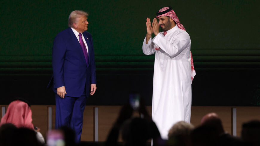 US President Donald Trump looks on as Saudi Crown Prince Mohammed bin Salman greets the crowd during the Saudi-US investment forum at the King Abdul Aziz International Conference Center in Riyadh on May 13, 2025. Saudi Arabia on May 13 promised billions of dollars in deals with the United States from defence to artificial intelligence as it threw a lavish welcome for President Donald Trump on the first state visit of his second term. (Photo by Fayez NURELDINE / AFP) (Photo by FAYEZ NURELDINE/AFP via Getty I