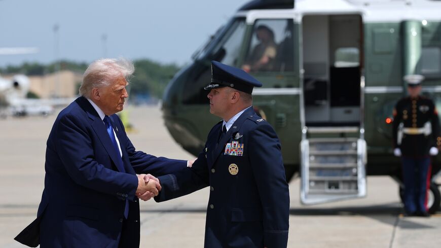 President Donald Trump is greeted by Air Force Col. Paul R. Pawluk as he arrives to board Air Force One on May 12, 2025, at Joint Base Andrews, Maryland.