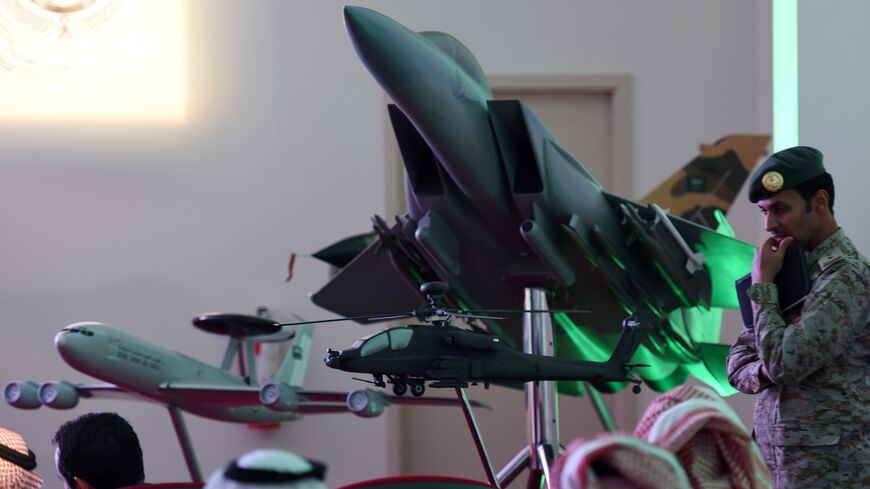 A member of Saudi security forces stands next to a replica of a fighter jet of the Saudi armed forces during the daily media briefing on Operation Decisive Storm, the Saudi-led coalition carrying out air strikes against Shiite Huthi militia in neighboring Yemen, on April 2, 2015 at the Air Base of the Saudi capital Riyadh.