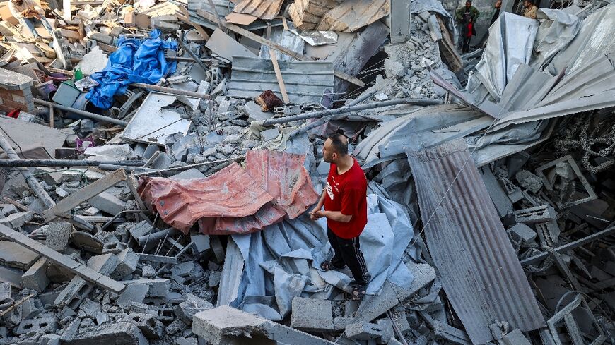 A man stands on the rubble of a building hit in an Israeli strike in the Bureij camp for Palestinian refugees in the central Gaza Strip 