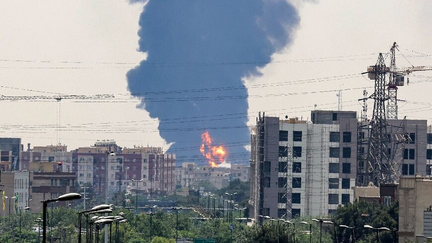 A plume of heavy smoke and fire rise over an oil refinery in southern Tehran, after an overnight Israeli strike