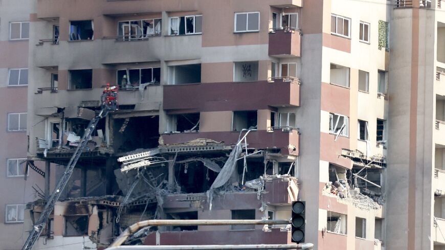 Rescue teams work outside a building targeted by an Israeli strike in the Iranian capital Tehran 