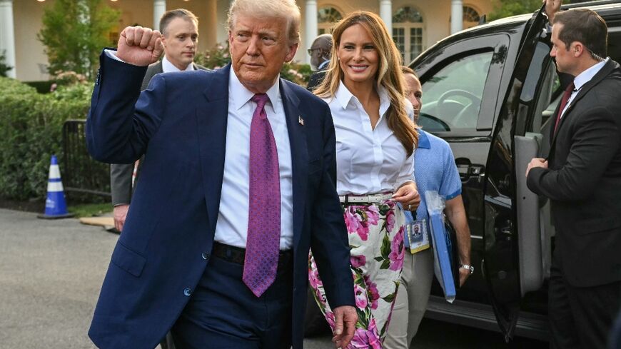 US President Donald Trump (L) raises a fist next to US First Lady Melania Trump during the Congressional Picnic on the South Lawn of the White House in Washington, DC, on June 12, 2025.