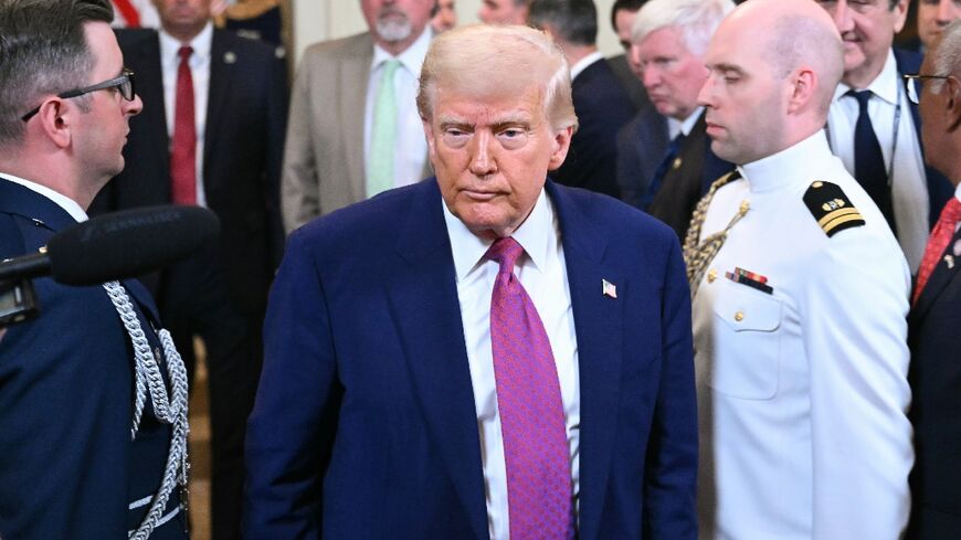 US President Donald Trump departs after signing a bill in the East Room of the White House 