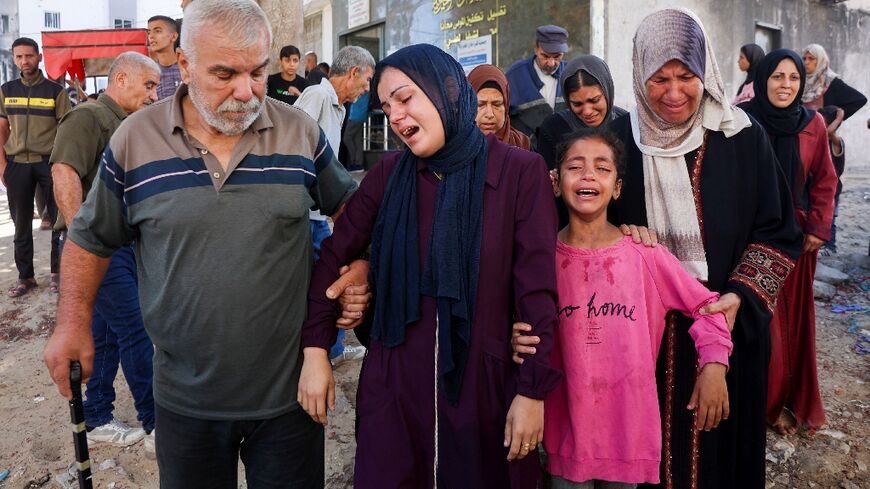 Mourners cry during a funeral of a person killed while attempting to get aid at a distribution point 