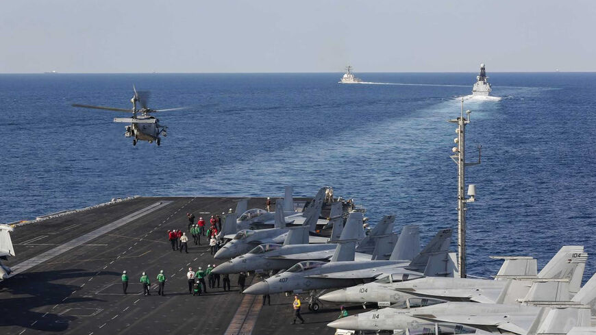 In this handout photo provided by the US Navy, the aircraft carrier USS Abraham Lincoln transits the Strait of Hormuz as an MH-60S Sea Hawk helicopter from the Nightdippers of Helicopter Sea Combat Squadron 5 lifts off from the flight deck, Nov. 19, 2019.