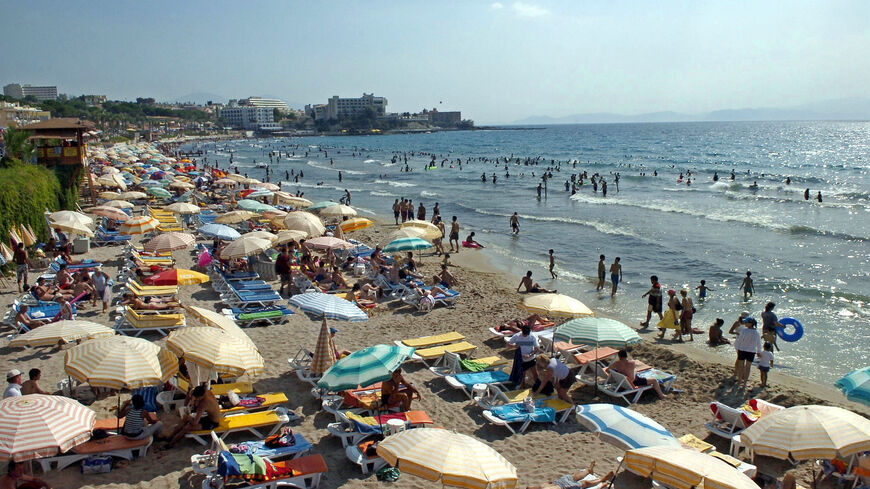People enjoy the sun and the sea along the Kadinlar Beach of Kusadasi on July 17, 2005.